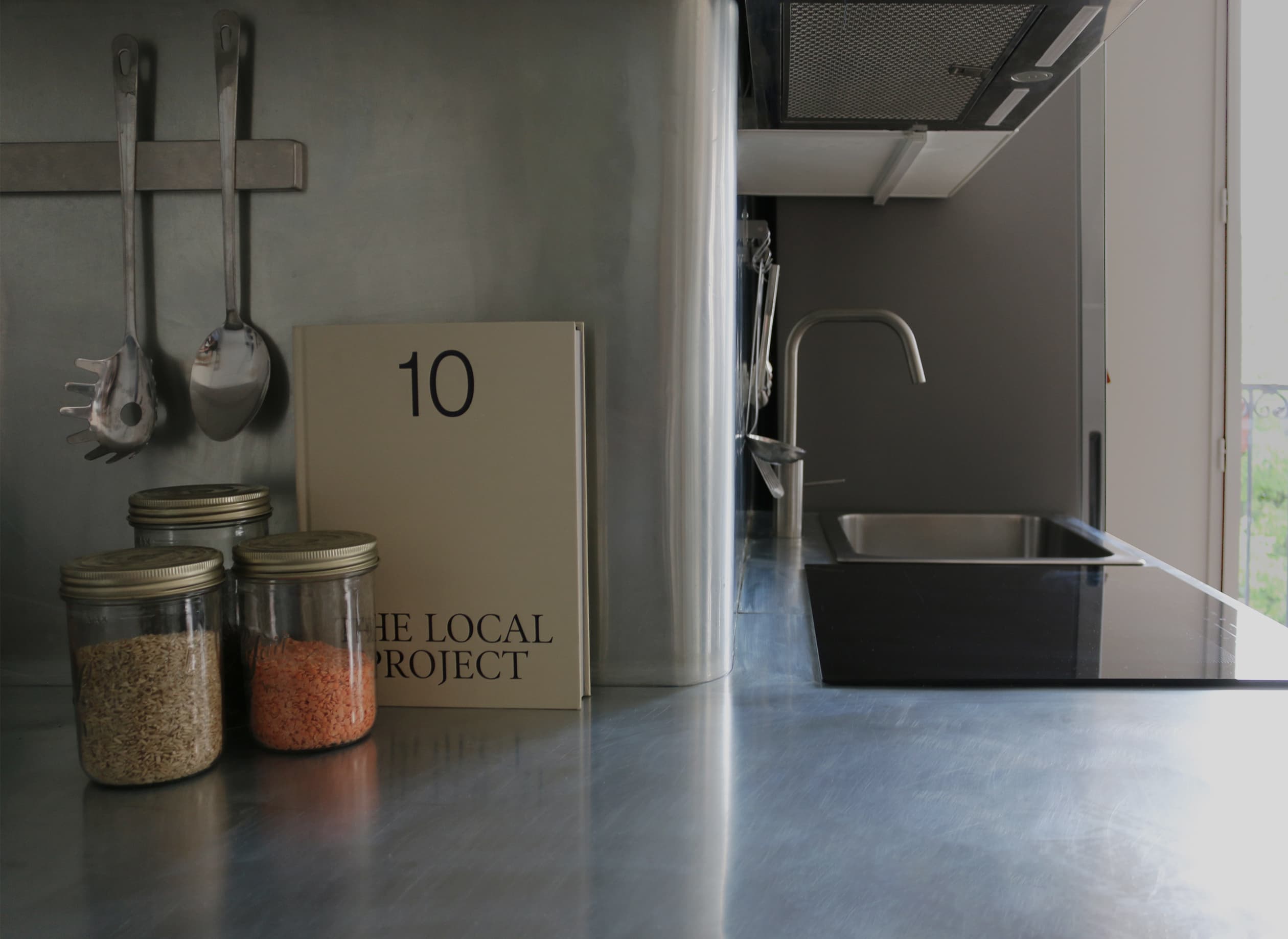 Cuisine sur-mesure de l’appartement Martinique : plan de travail et crédence en zinc, design contemporain signé Plié Architectes.